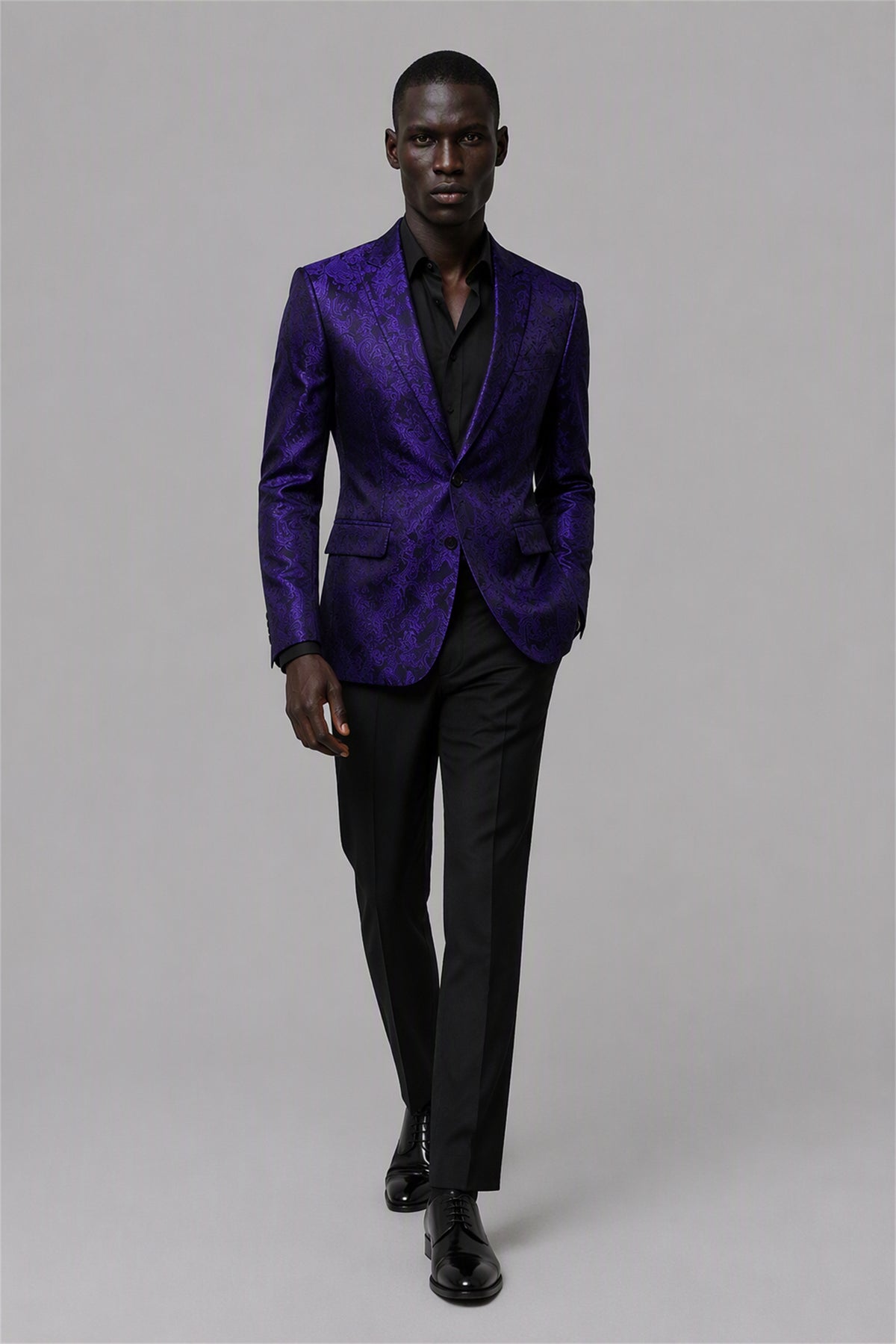 Savile Purple Paisley Jacquard Tuxedo Jacket – Full front walking view showing deep purple paisley jacquard jacket with black satin peak lapel, black shirt and black trousers