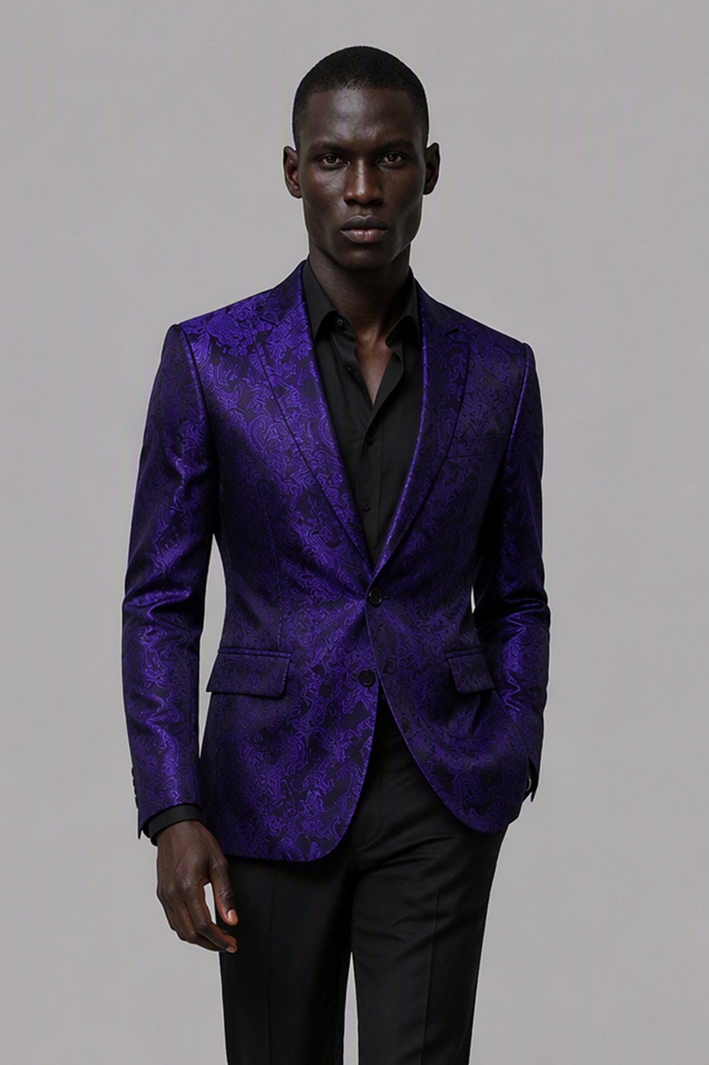 Savile Purple Paisley Jacquard Tuxedo Jacket – Three-quarter front view, hand on button showing purple paisley texture and black satin peak lapel detail
