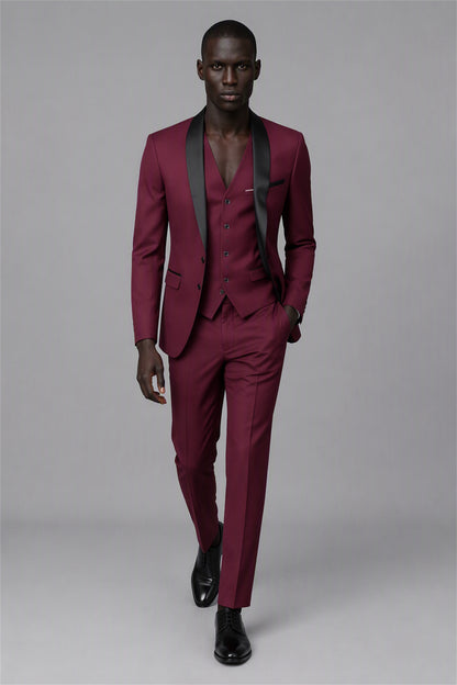 Savile Burgundy 3-Piece Tuxedo Set – Three-quarter front view, hand on lapel showing slim-fit silhouette, shawl lapel profile and vest detail