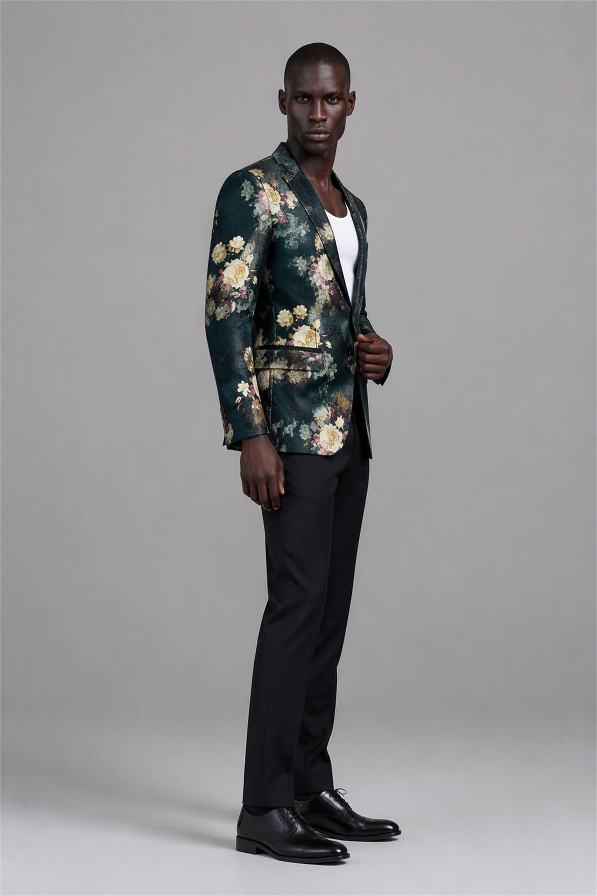 Savile Emerald Green Floral Jacquard Blazer – Full rear three-quarter view with black shirt showing emerald floral jacquard back construction, structured shoulders and tapered black trouser fit